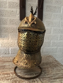 A beautiful metal brass knight helmet on stand.